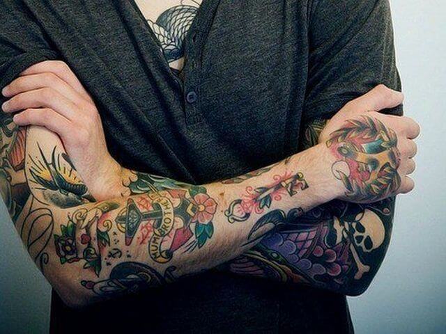 homem com tatuagem nos braços