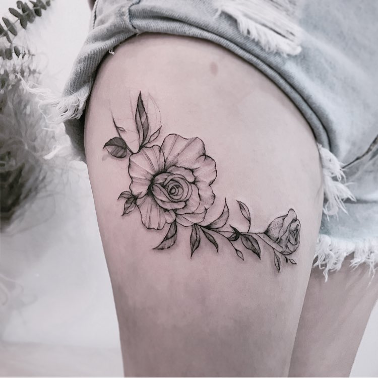 tatuagem feminina de flores na coxa