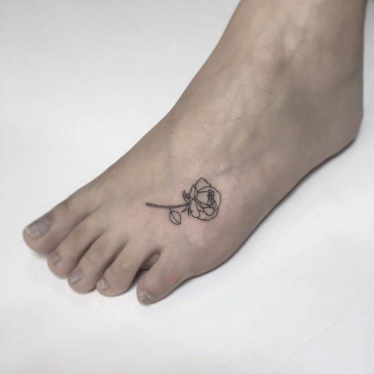 tatuagem feminina de traços finos no pé