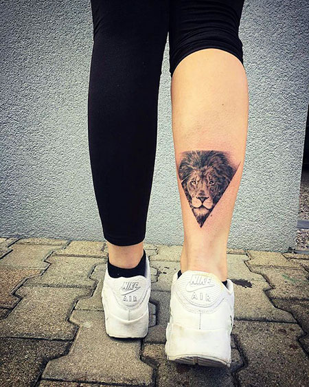 Tatuagem feminina de leão na panturrilha