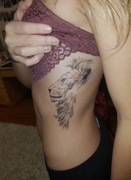 Tatuagem feminina de leão nas costelas