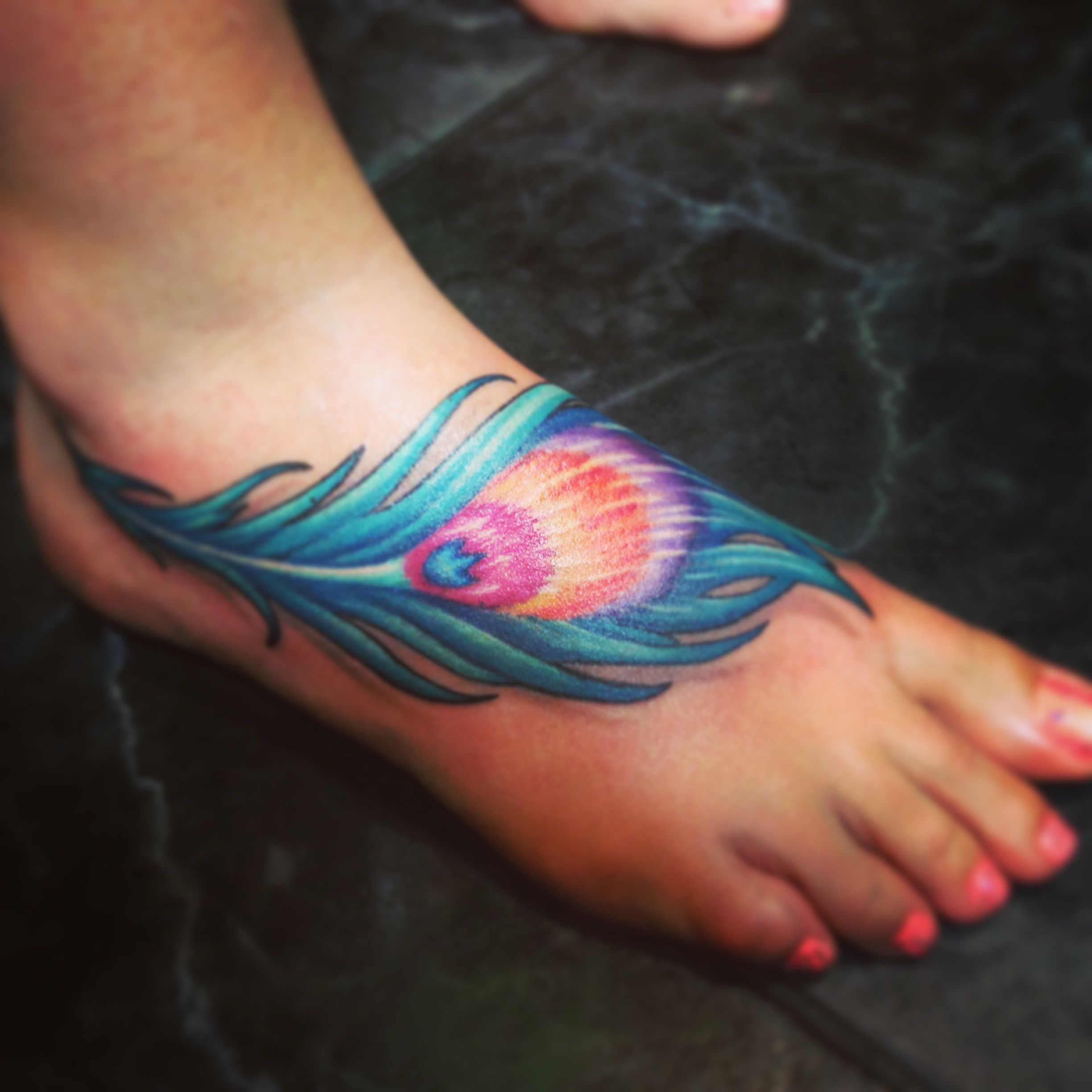 tatuagem feminina no pé de penas