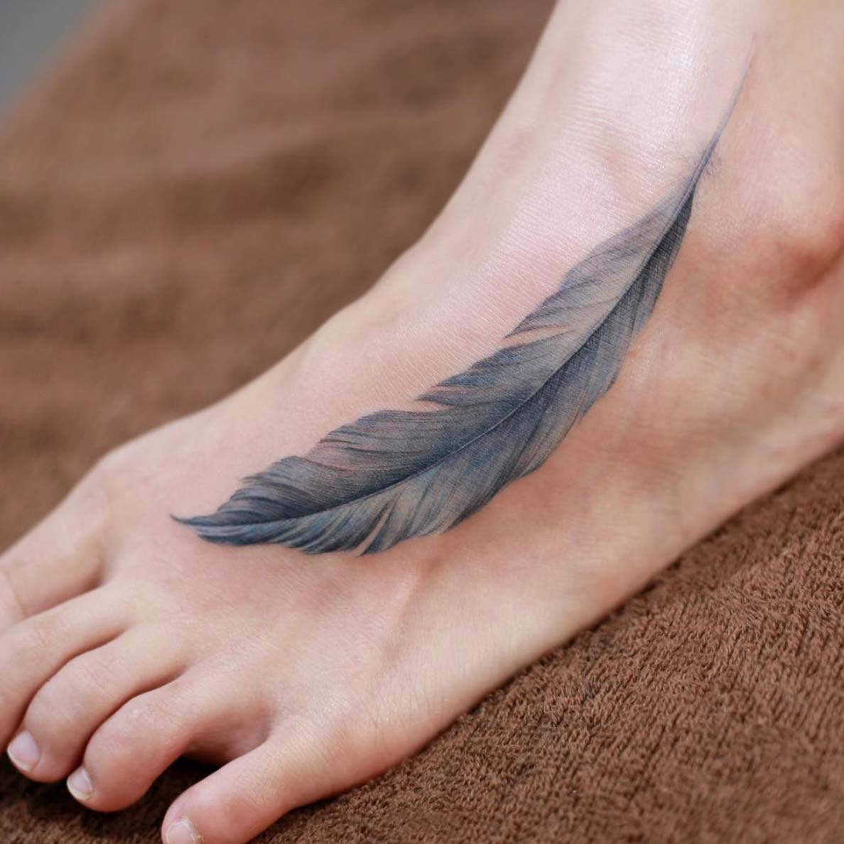 tatuagem feminina no pé de penas 2021