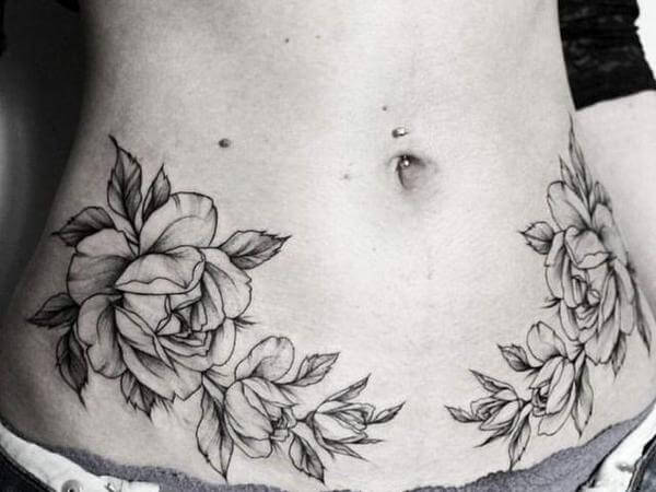 Tatuagem de rosas na barriga feminina