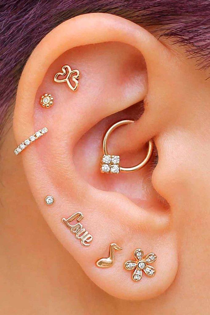 vários piercings na orelha