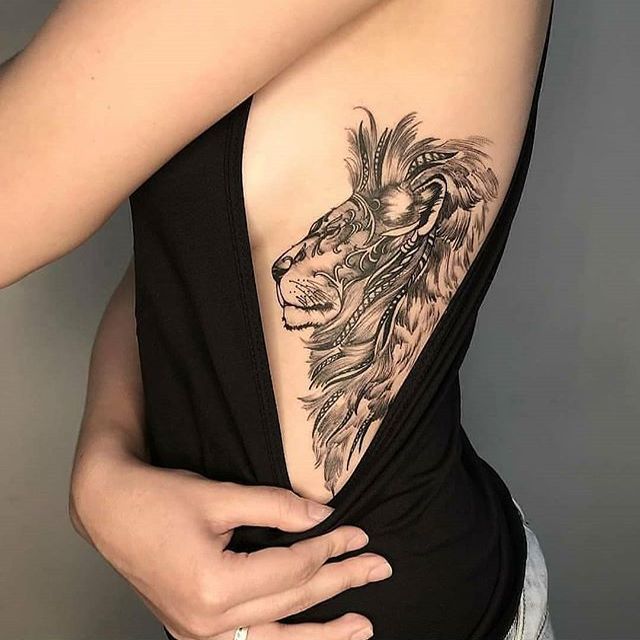 Tatuagem feminina de leão nas costelas