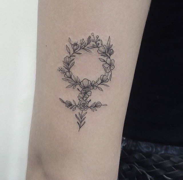 tatuagem feminina de símbolo no braço