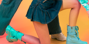 Estilos que já foram tendência em 1990. Foto mostra uma pessoa vestido saia jeans com coturno azul
