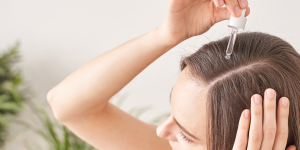 Hair Oiling. Foto mulher passando óleo na raiz do cabelo