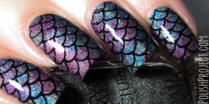 Unhas de Sereia- Pinterest. Foto mostra uma unha com esmalte roxo e azul com escamas de peixe em preto e brilho. Os dedos estão segurando um esmalte de cor preta brilhante