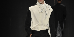 Looks com camisa e alfaiataria inspiradas em Igor Danona. Foto mostra um modelo na passarela vestindo camisa social branca e preta com colarinho.