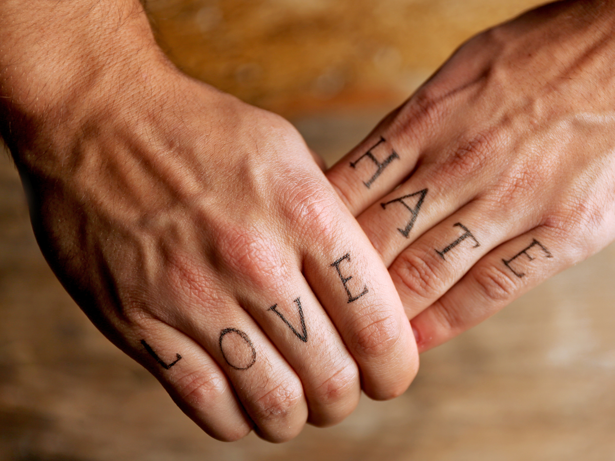 Tatuagem no dedo. Foto aparece mãos com tatuagem de letras uma em cada dedo com a escrita LOVE HATE