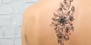 Tatuagens para as costas. Foto traz uma tatuagem nas costas em formato de flores.