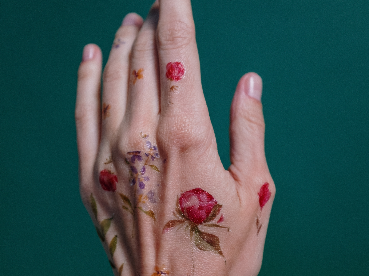 Ideias de tatuagens nas mãos. Foto mão com tatuagem de rosas.