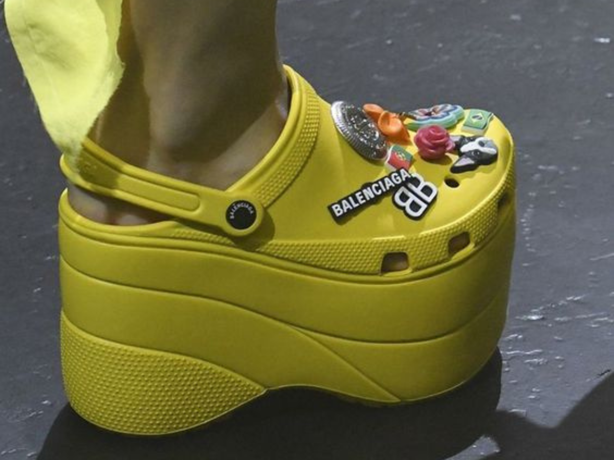 Crocs de Salto. Foto mostra modelo crocs de cor amarelo com detalhes na parte de cima e escrita balenciaga.