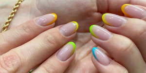Unhas Francesinhas Coloridas verão.Foto mostra mão com a técnica com cores amarelas e azuis