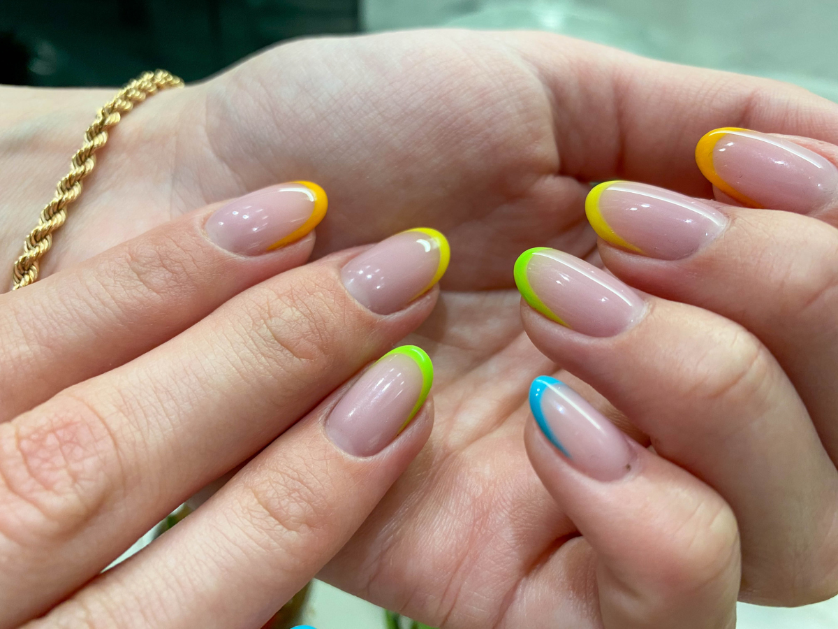 Unhas Francesinhas Coloridas verão.Foto mostra mão com a técnica com cores amarelas e azuis