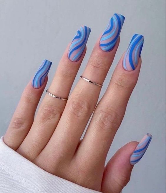 unhas com desenhos geométricos azuis